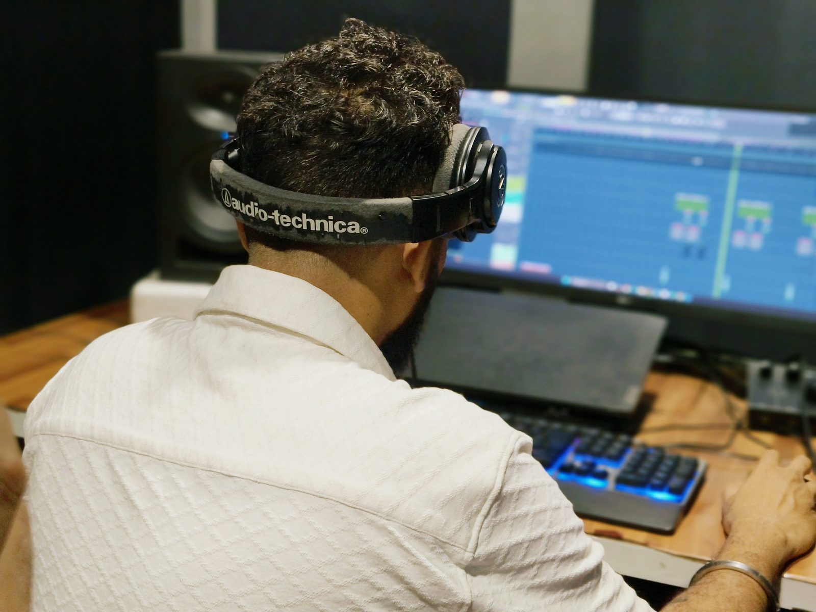 Producer wearing headphones while working on a music session