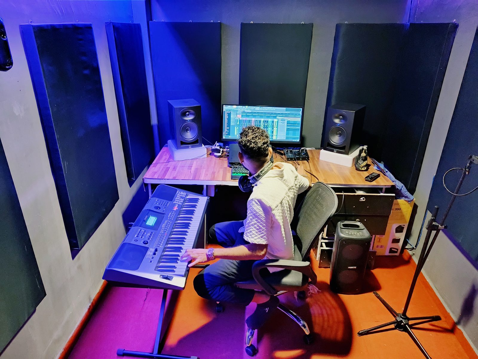 Wide view of Neone Wave Production studio with keyboard, monitors, and acoustic panels